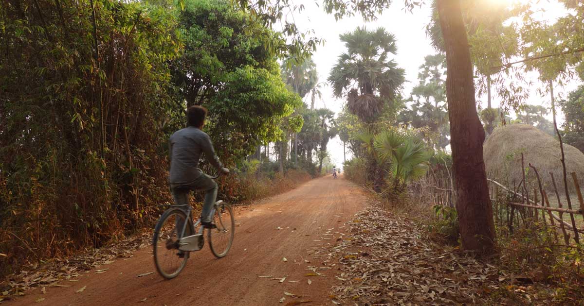 Man rides bike on dirt road