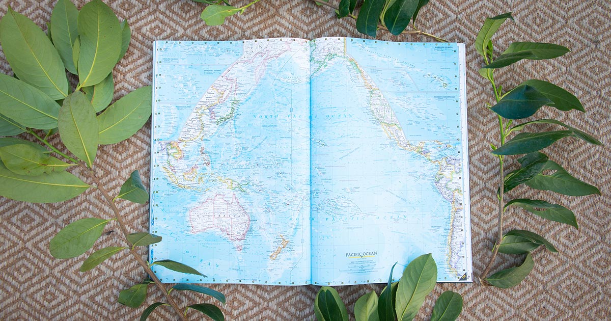 Map book of the world rests on the floor, open to the South Pacific pages.