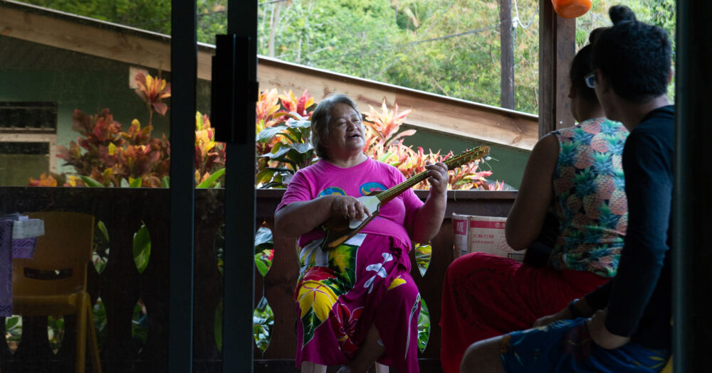 A woman singing on her porch.